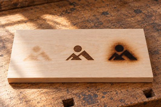 Illustrative maple board with three flat surface burns of the same logo: faint, crisp, and scorched
