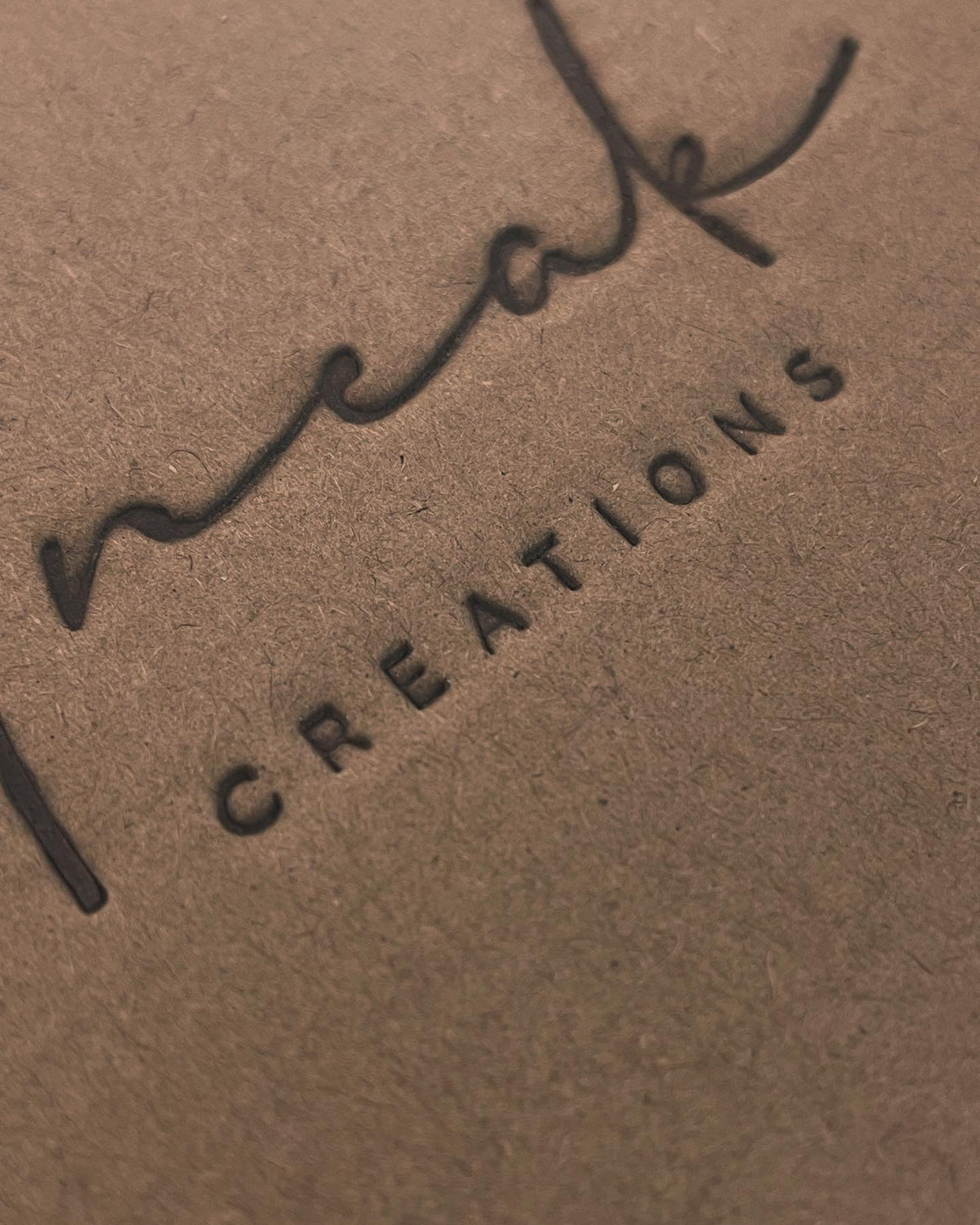 Real archival direct heat branding on Uneak Creations cardboard packaging; no foil